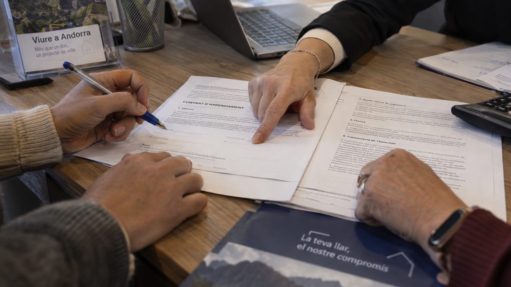Firma de un contrato de servicio doméstico sobre la mesa de una agencia en Andorra