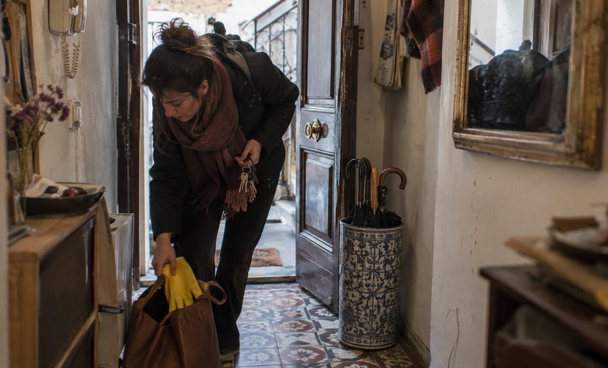 Buscar trabajo de limpieza por horas Mujer llegando a trabajar de limpieza por horas a una casa particular y sacando los guantes