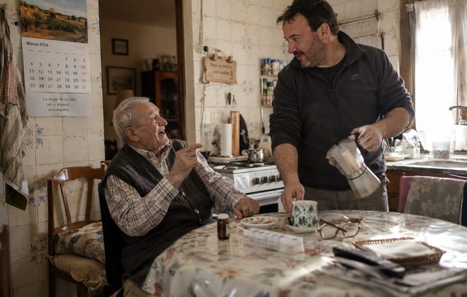 Cuidado de personas mayores a domicilio Cuidador sirviendo un café a un señor mayor en la cocina de su casa