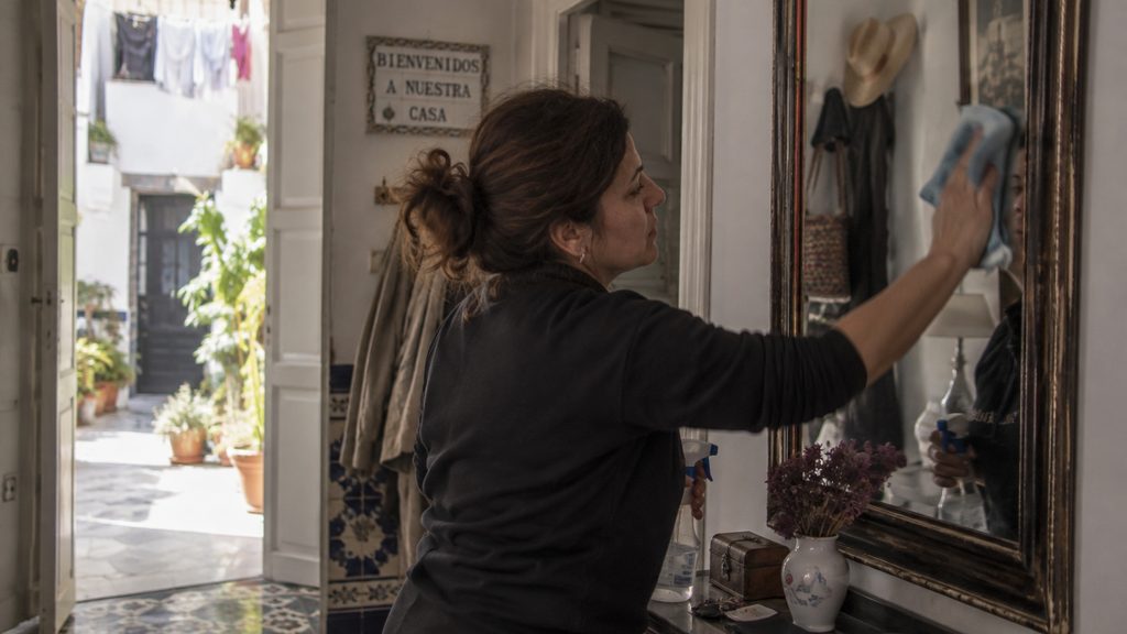 Empleada de hogar trabajando en el recibidor en una vivienda de Cádiz