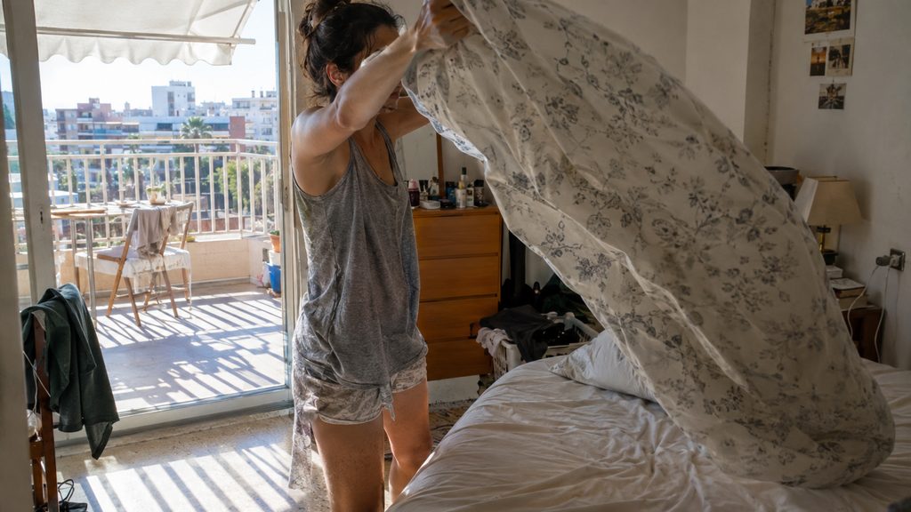 Empleada de hogar trabajando en el dormitorio principal en una vivienda de Málaga