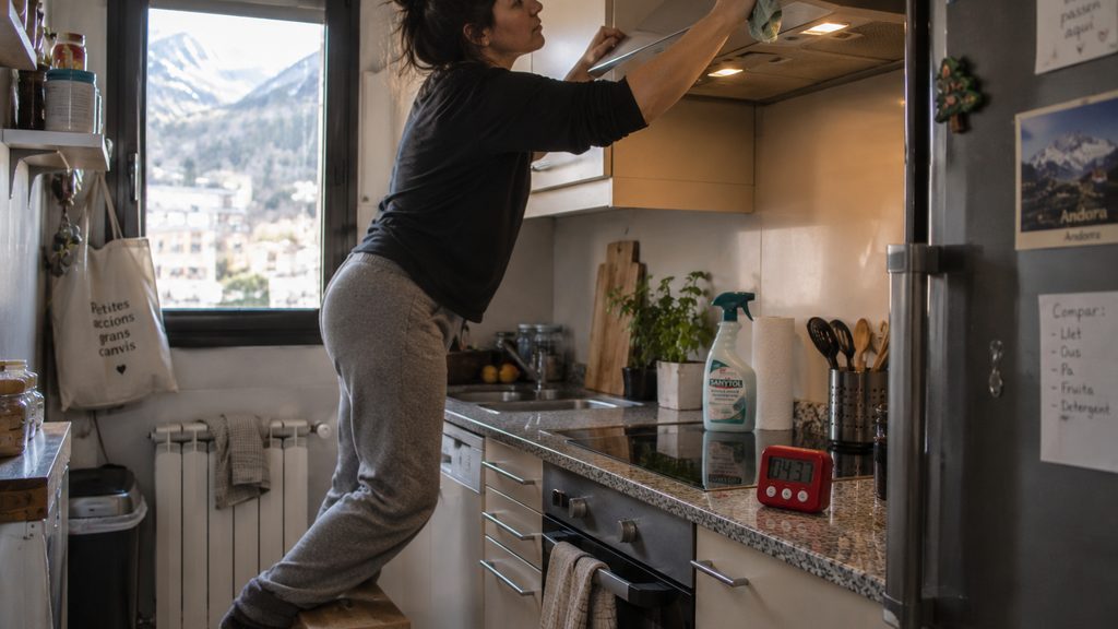 Mujer limpiando la campana de una cocina de Encamp durante un servicio de limpieza por horas
