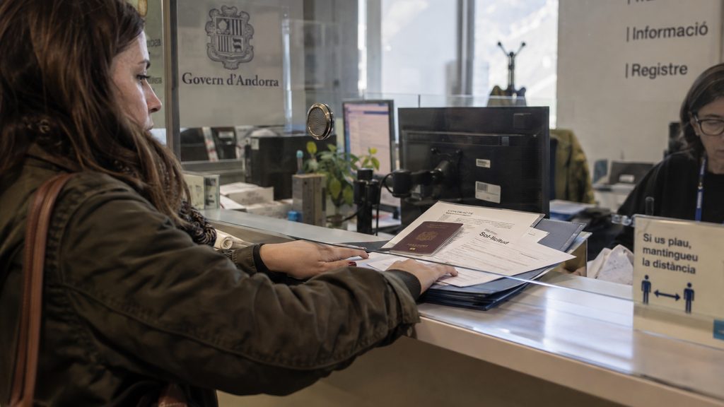Documentación del permiso de trabajo de empleada de hogar sobre el mostrador de una ventanilla en Andorra