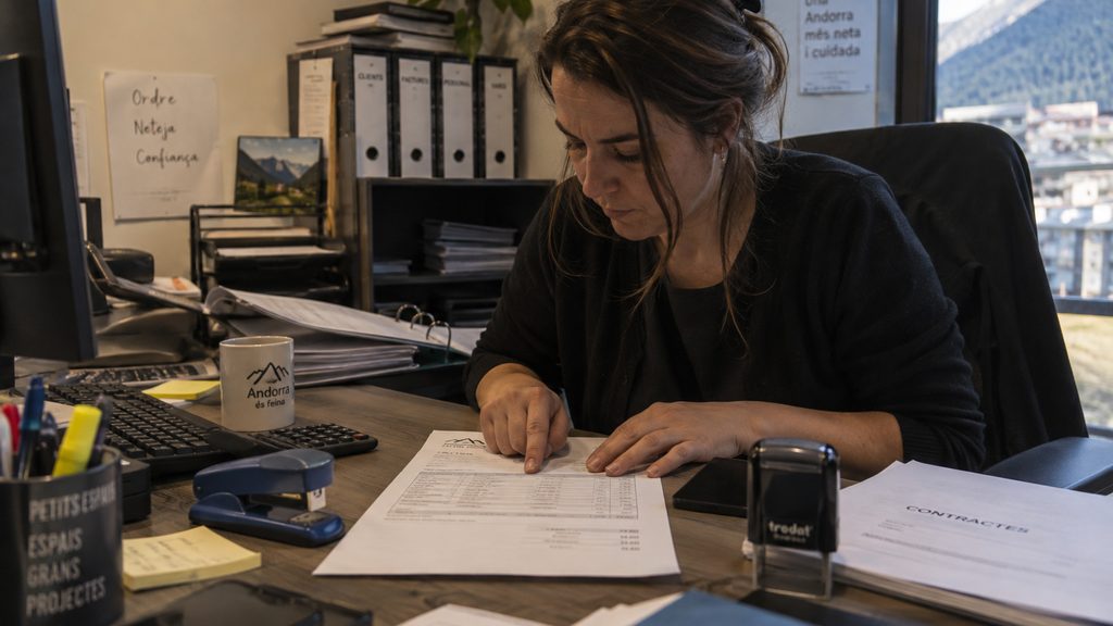 Mujer revisando la factura mensual de una empresa de limpieza en un despacho de Andorra